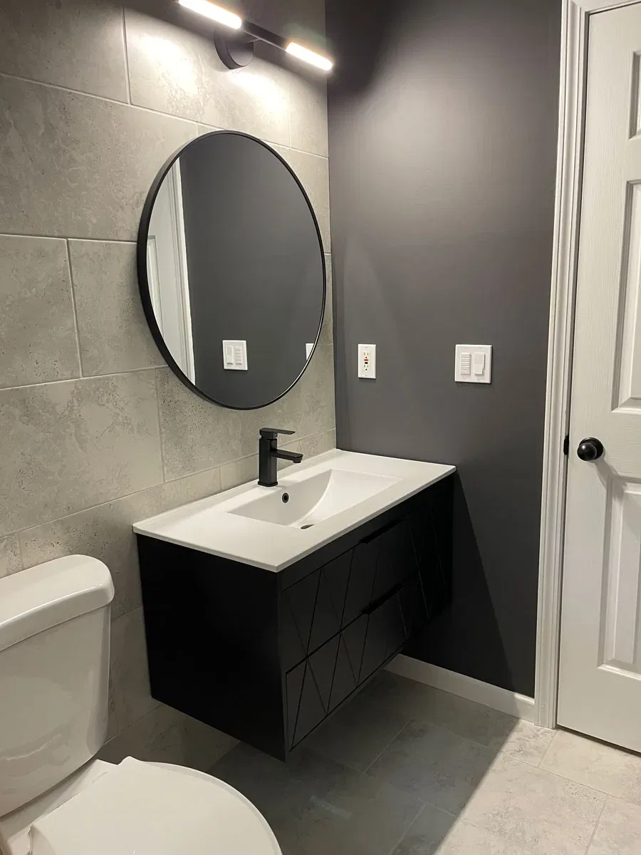 Modern bathroom with circular mirror and geometric vanity